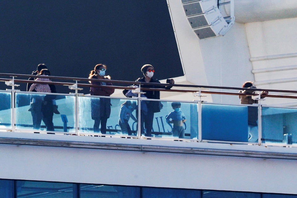 Passengers and children stand on the deck of the cruise ship Diamond Princess, as the vessel's passengers continue to be tested for coronavirus, at Daikoku Pier Cruise Terminal in Yokohama, south of Tokyo, Japan February 13, 2020. REUTERS/Kim Kyung-Hoon