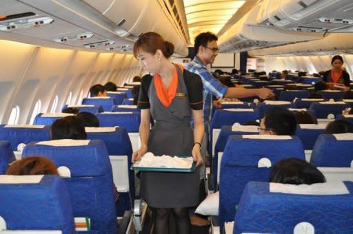 Transsexual fight attendant Chayathisa Nakmai (centre) works onboard a Thai PC Air flight between Bangkok and Hong Kong on March 9. Fledgling Thailand-based carrier PC Air has hired four transgender cabin crew in a highly publicised recruitment drive that has divided opinion over whether the move is in the spirit of equality or exploitation