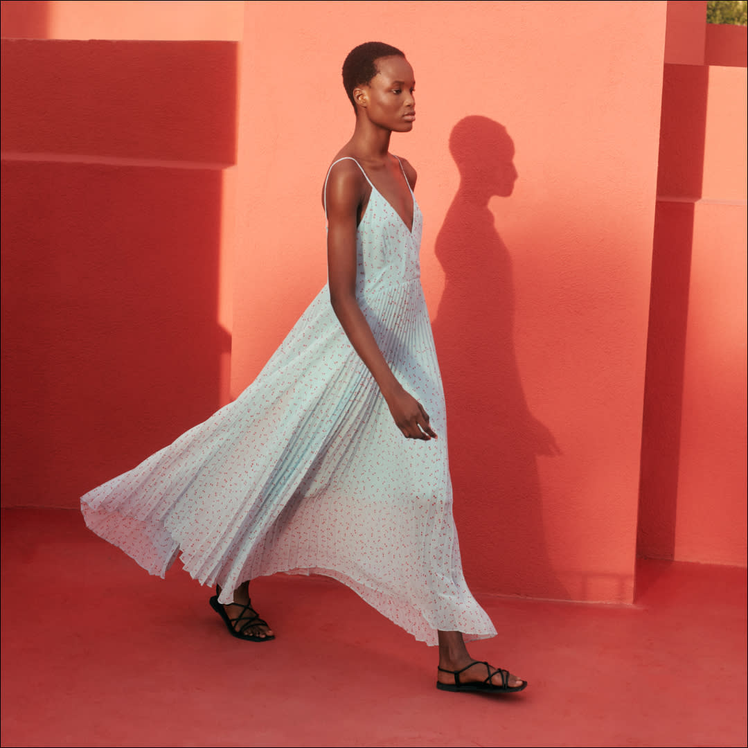  A woman wearing a blue dress from Clare Waight Keller's Spring 2024 Uniqlo:C collection. 