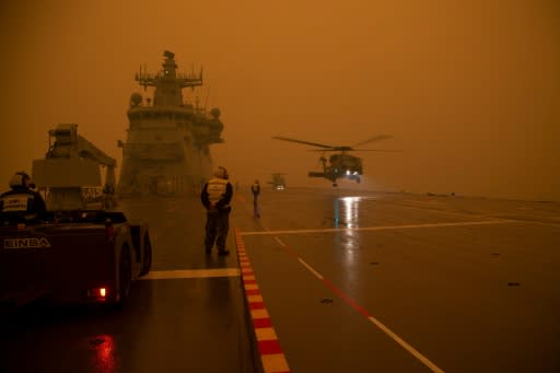 Royal Australian Navy MH-60R Seahawk helicopters taking off from HMAS Adelaide as part of bushfire relief operations -- Australia has made its biggest-ever callup of military reserves in living memory, to help emergency services workers