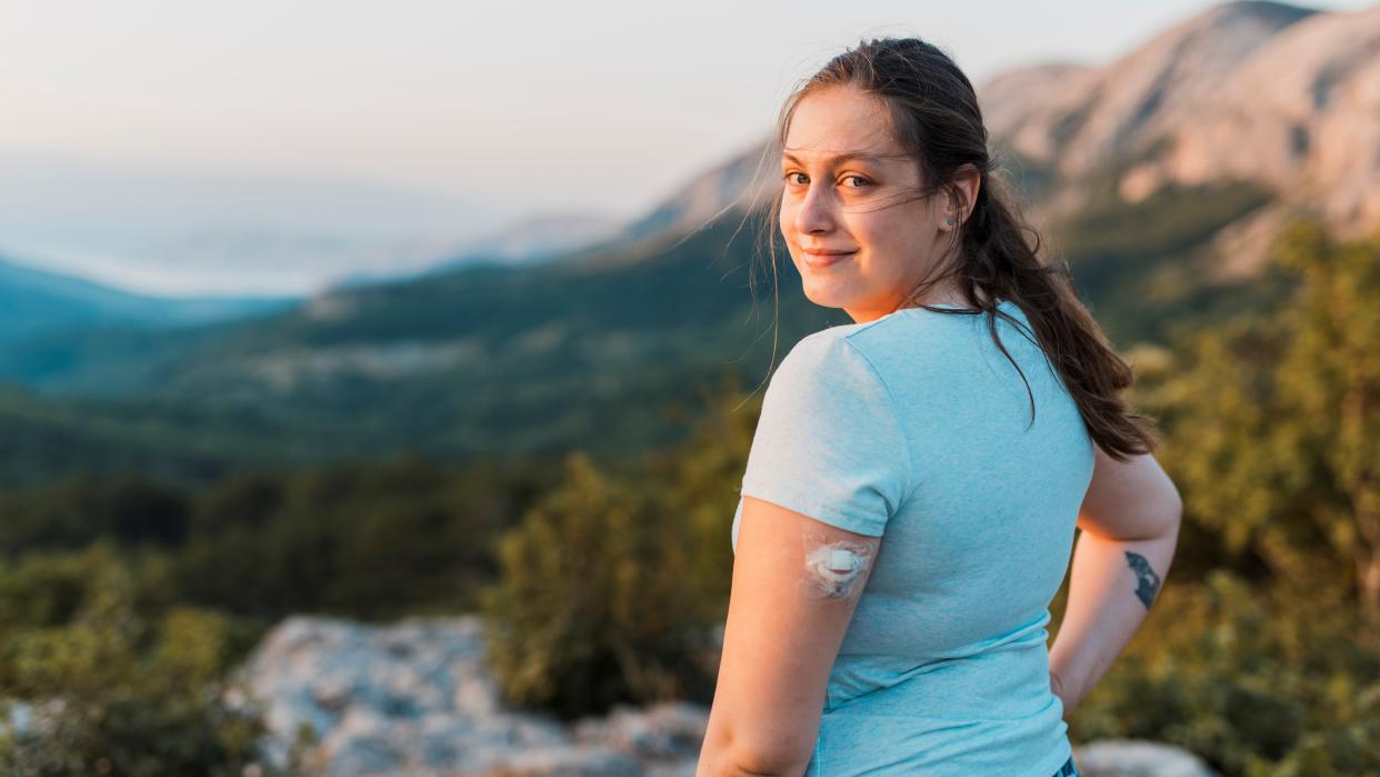  Woman with diabetes standing on top of the hill and looking at camera. 