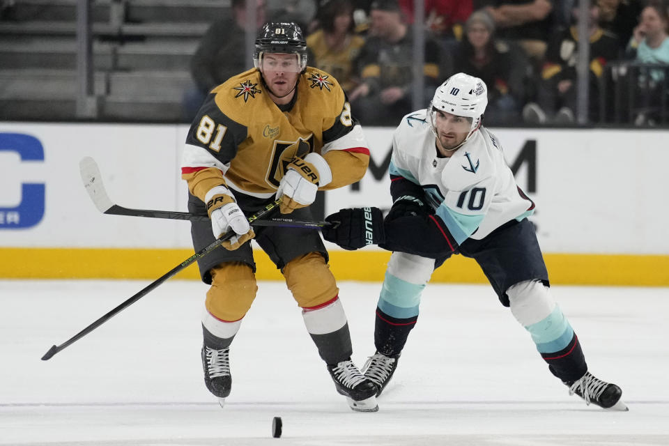 Vegas Golden Knights right wing Jonathan Marchessault (81) and Seattle Kraken center Matty Beniers (10) battle for the puck during the first period of an NHL hockey game Tuesday, April 11, 2023, in Las Vegas. (AP Photo/John Locher)