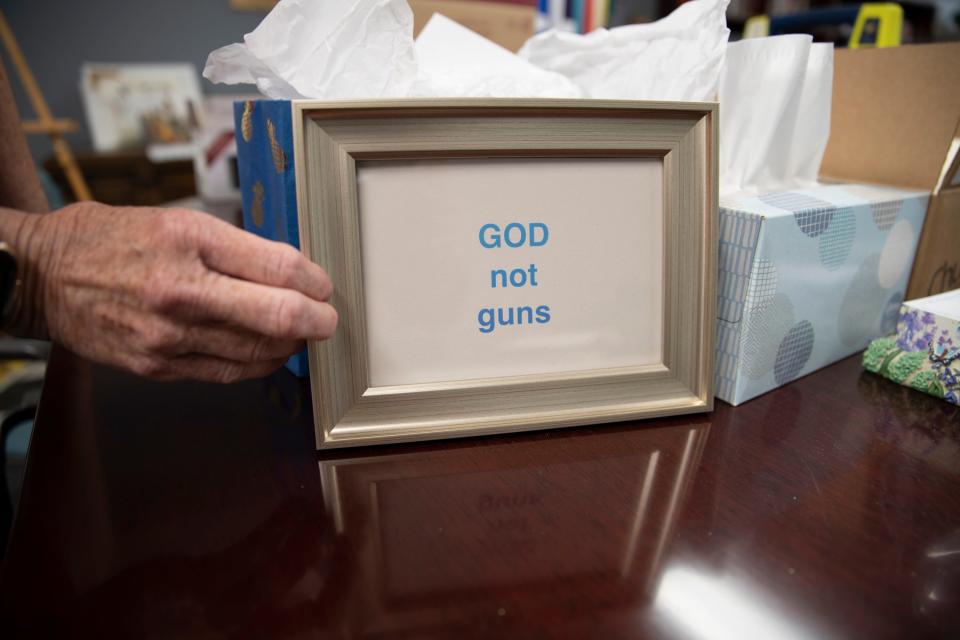 Pastor Vickie Van Nevel adjusts a sign that reads "GOD not guns" at First United Methodist Church in downtown South Bend on June 14, 2023. Van Nevel makes a point of understanding the importance of creating a space where people can speak openly within the church about their experiences surrounding gun violence to create a place to heal from trauma related to its prevalence as an issue in the United States today.