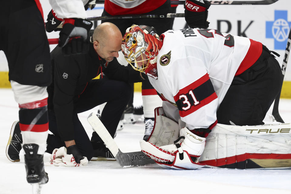 Ottawa Senators goaltender Anton Forsberg (31) talks with a trainer during the first period of the team's NHL hockey game against the Buffalo Sabres on Thursday, Jan. 11, 2024, in Buffalo, N.Y. (AP Photo/Jeffrey T. Barnes)