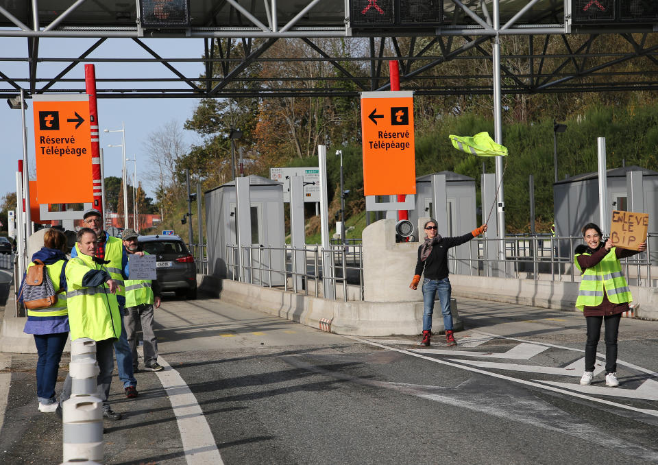 Demonstrators open the toll gates on motorway near Biarritz, southwestern France, Tuesday, Dec.4, 2018. French Prime Minister Edouard Philippe announced a suspension of fuel tax hikes Tuesday, a major U-turn in an effort to appease a protest movement that has radicalized and plunged Paris into chaos last weekend. (AP Photo/Bob Edme)