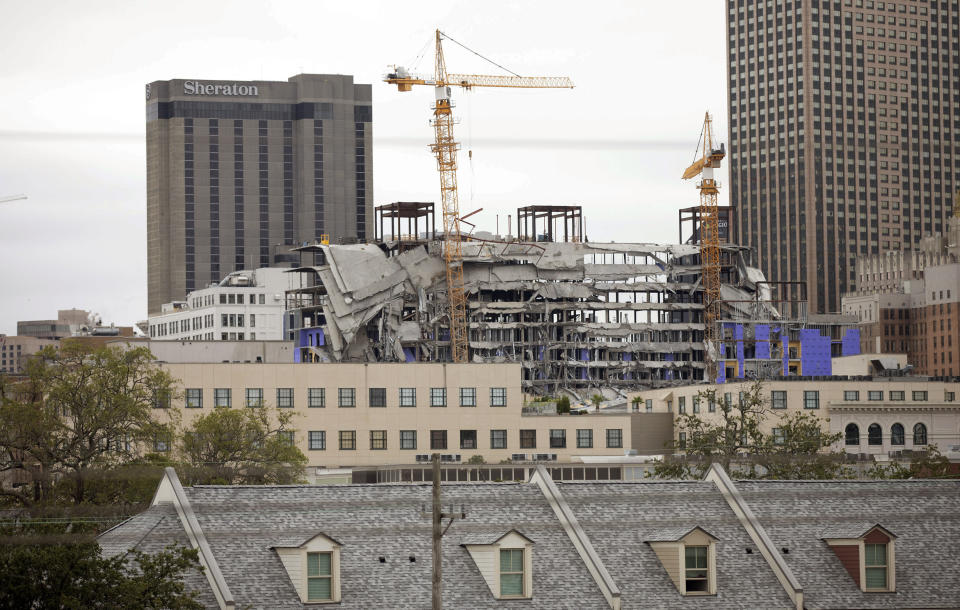 Debris hangs on the side of the building after a large portion of a hotel under construction suddenly collapsed in New Orleans on Saturday, Oct. 12, 2019. Several construction workers had to run to safety as the Hard Rock Hotel, which has been under construction for the last several months, came crashing down. It was not immediately clear what caused the collapse or if anyone was injured. (David Grunfeld/The Advocate via AP)