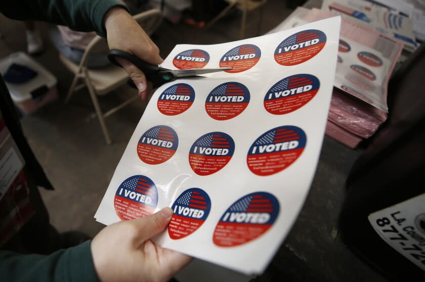 SANTA MONICA, CA - SEPTEMBER 14: Vote center lead Rachel Hadlock-Piltz, prepares "I VOTED" stickers for voters casting their ballots in a vote center at Santa Monica College as polls open Tuesday morning for Californians to decide whether Gov. Gavin Newsom should be removed from office and, if so, who should replace him in a recall election. "I really enjoy this part of the job," Rachel said. Santa Monica College on Tuesday, Sept. 14, 2021 in Santa Monica, CA. (Al Seib / Los Angeles Times).