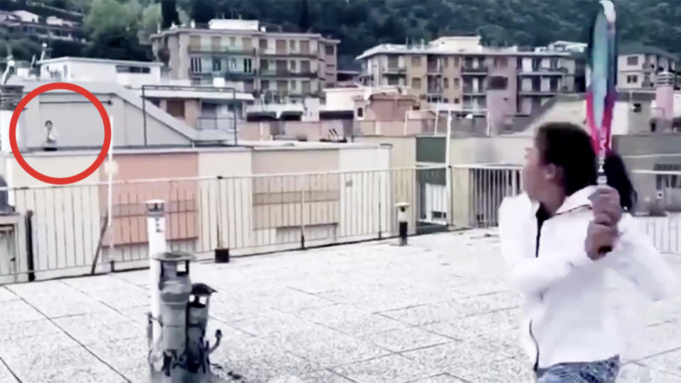 Two Italian girls hit the tennis ball back and forth on their rooftops.