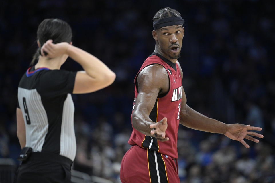 Miami Heat forward Jimmy Butler, right, questions a call with official Natalie Sago (9) during the first half of an NBA basketball game against the Orlando Magic, Saturday, March 11, 2023, in Orlando, Fla. (AP Photo/Phelan M. Ebenhack)