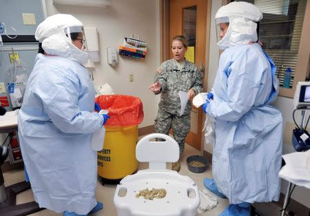 Maj. Heather Delaney (C) instructs participants on the proper method of containing infectious bodily fluids during training for the Ebola response team at Fort Sam Houston in San Antonio, Texas October 24, 2014. REUTERS/Darren Abate