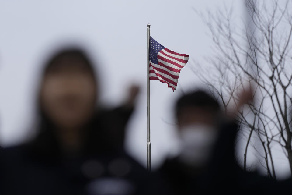 The U.S. flag is seen at the U.S. Embassy as protesters shout slogans during an anti-U.S. rally in Seoul, South Korea, Friday, March 17, 2023. North Korea said Friday it fired an intercontinental ballistic missile to "strike fear into the enemies" as South Korea and Japan agreed at a summit to work closely on regional security with the United States and staged military exercises around the region.(AP Photo/Lee Jin-man)