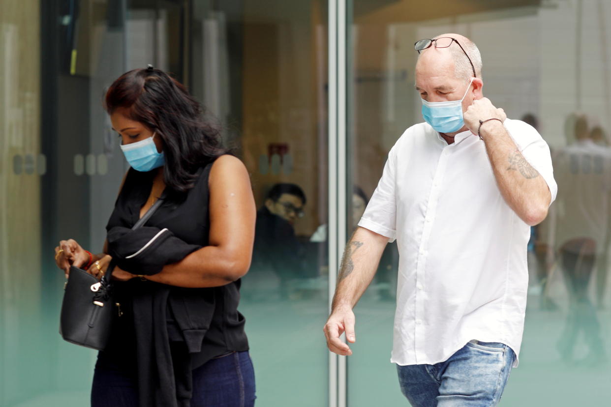 Briton Skea Nigel and partner Agatha Maghesh Eyamalai arrive at the State Courts for a hearing after breaking coronavirus disease (COVID-19) quarantine regulations in Singapore February 15, 2021.  REUTERS/Edgar Su