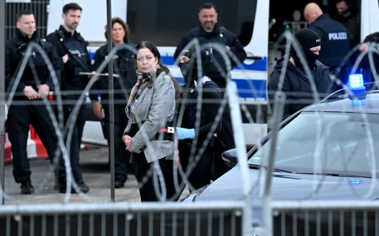 Policemen stand guard in front of a hall set up as a courtroom as judge and former MP for the far-right Alternative for Germany Birgit Malsack-Winkemann (4th L) and other defendants (not in picture) arrive for the trial against a prince, a former MP and ex-army officers accused of masterminding a conspiracy theory-driven plot to attack the German parliament and topple the government, on May 21, 2024 in Frankfurt am Main, western Germany. In one of the biggest cases heard by German courts in decades, prosecutors accuse the group of preparing a "treasonous undertaking" to storm the Bundestag (German parliament) and take MPs hostage. The proceedings at the regional court in Frankfurt are the second of three trials against defendants linked to the putsch plan. Eight suspected members of the coup plot will take the stand in Frankfurt, as well as one woman accused of supporting their efforts to overthrow Chancellor Olaf Scholz's government. (Kirill KUDRYAVTSEV)
