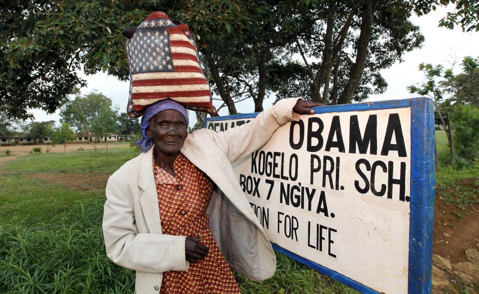 Rosa Anyango poses for a photograph as she carries a bag with the colors of the U.S. flag as she walks from the market near the ancestral home of U.S. President Barack Obama in Nyangoma village in Kogelo, west of Kenya's capital Nairobi, June 22, 2015. When Barack Obama visits Africa this month, he will be welcomed by a continent that had expected closer attention from a man they claim as their son, a sentiment felt acutely in the Kenyan village where the 44th U.S. president's father is buried. Picture taken June 22, 2015. (REUTERS/Thomas Mukoya)