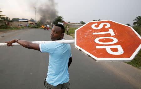 A protester carries a traffic sign during a protest against Burundi President Pierre Nkurunziza and his bid for a third term in Bujumbura, Burundi, May 26, 2015. REUTERS/Goran Tomasevic