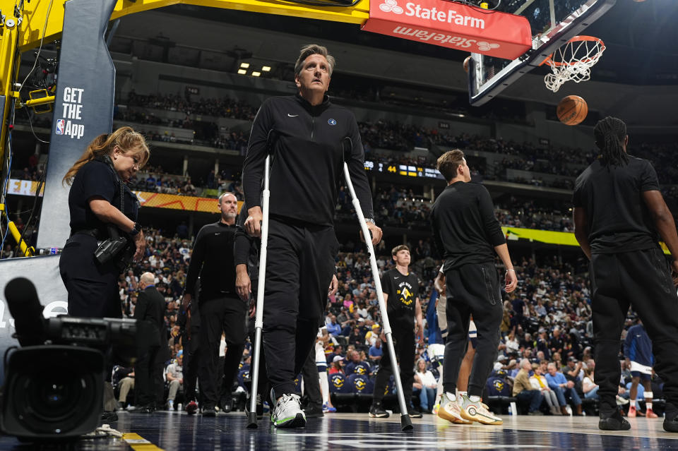 Minnesota Timberwolves head coach Chris Finch uses crutches to head to the bench in the second half of Game 1 of an NBA basketball second-round playoff series against the Denver Nuggets Saturday, May 4, 2024, in Denver. (AP Photo/David Zalubowski)