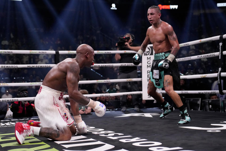 Yordenis Ugas, left, kneels after being knocked down by Mario Barrios in a welterweight boxing match Saturday, Sept. 30, 2023, in Las Vegas. (AP Photo/John Locher)