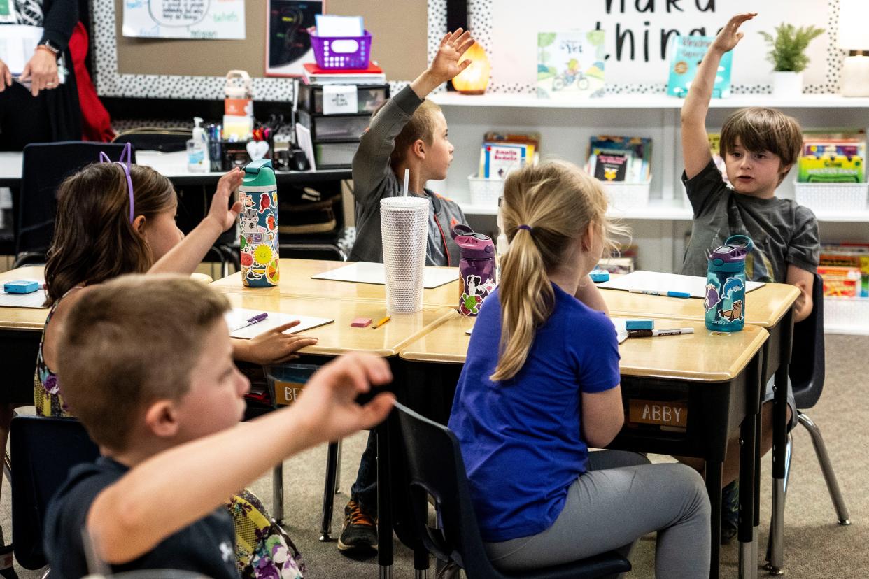 Students raise their hands to answer questions in Adel Elementary School first grade teacher Erin Koelker's classroom at Adel Elementary School on Tuesday, May 7, 2024, in Adel.