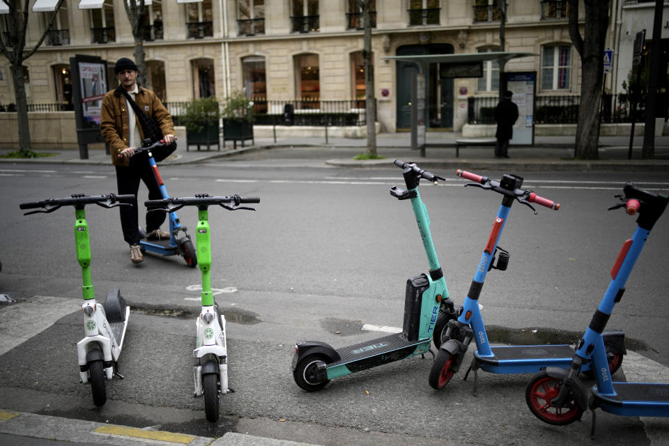 A man parks a scooter in Paris, Friday, march 31, 2023. Romantically zipping two-to-a-scooter, wind in the hair, past the Eiffel Tower and other iconic sights could soon become a thing of the past if Parisians vote Sunday to do away with the 15,000 opinion-dividing micro-machines. (AP Photo/Christophe Ena)