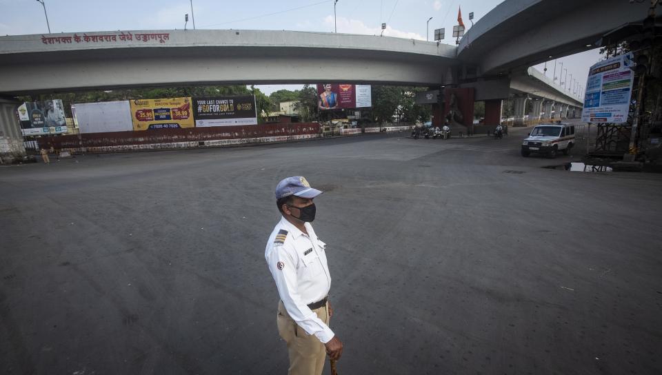 PUNE, INDIA - MARCH 26: A lone traffic policeman stands at deserted Swargate chowk, on March 26, 2020 in Pune, India. Prime Minister Narendra Modi on Tuesday announced complete lockdown of the entire country, as part of the governments stringent efforts to tackle coronavirus disease Covid-19. This lockdown will be in place for 21 days and more stringent than Janta Curfew. Although, ration shops, groceries, fruits and vegetable shops, dairy and milk booths, meat and fish shops, animal fodder will remain open during the 21-day lockdown. (Photo by Pratham Gokhale/Hindustan Times via Getty Images)