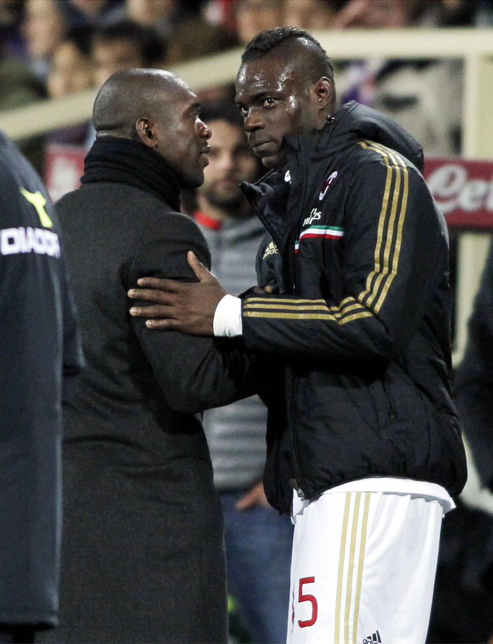 AC Milan coach Clarence Seedorf, left, greets Mario Balotelli during a Serie A soccer match against Fiorentina at the Artemio Franchi stadium in Florence, Italy Wednesday, March 26, 2014. (AP Photo/Fabrizio Giovannozzi)