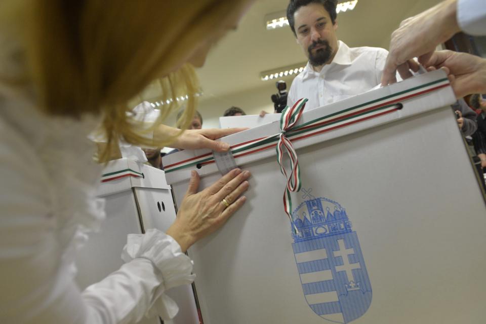 Electoral officials seal a ballot box at a polling station in Budapest during the parliamentary elections in Hungary, Sunday April 6, 2014. Hungary's governing party is tipped to win parliamentary elections Sunday, while a far-right party is expected to make further gains, according to polls. Prime Minister Viktor Orban's Fidesz party and its small ally, the Christian Democrats, are expected to win easily and they may even retain the two-thirds majority in the legislature gained in 2010 which allowed them to pass a new constitution, adopt unconventional economic policies, centralize power and grow the state's influence at the expense of the private sector. (AP Photos/MTI,Zoltan Mathe)