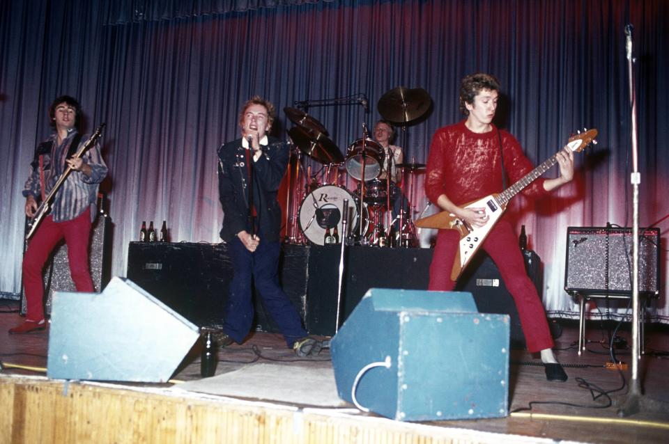 UNITED KINGDOM - OCTOBER 21:  Photo of Johnny ROTTEN and SEX PISTOLS and Glen MATLOCK and Paul COOK; L-R: Glen Matlock, Johnny Rotten (John Lydon), Paul Cook, Steve Jones performing live onstage at Dunstable's Queensway Hall  (Photo by Chris Morphet/Redferns)