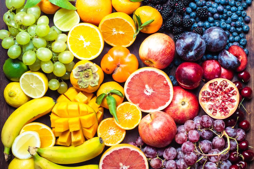 A colourful spectrum of fruit: oranges, lemons, limes, mandarins, grapes, plums, grapefruit, pomegranate, persimmons, bananas, cherries, apples, mangoes, blackberries and blueberries.
