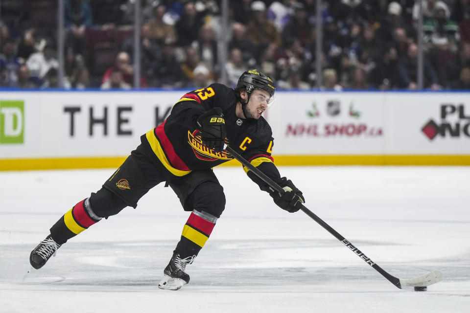 Vancouver Canucks' Quinn Hughes passes the puck during the first period of an NHL hockey game against the Tampa Bay Lightning in Vancouver, B.C., on Tuesday, Dec. 12, 2023. (Darryl Dyck/The Canadian Press via AP)