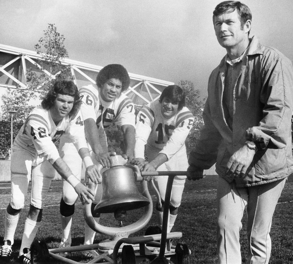 UCLA coach Dick Vermeil is joined by Bruins' captains Jeff Smith, Cliff Frazier, and John Sciarra on Dec. 15, 1975 to push the victory bell won in the UCLA-USC game to end the regular season the previous month. The Bruins were getting ready for the Rose Bowl against Ohio State, which they won Jan. 1, 1976.