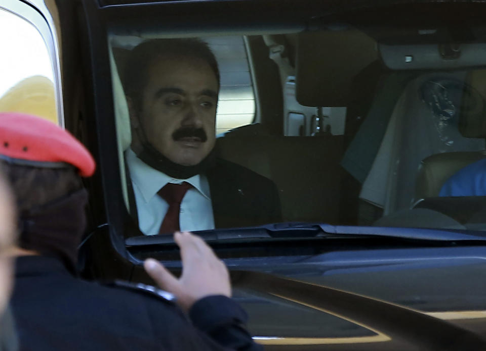 Defense lawyer Mohammad Afeef, who represents Bassem Awadallah, is driven from a State Security Court, where the trial of Awadallah, a former royal adviser, and Sharif Hassan bin Zaid, a distant cousin of the king, is taking place, in Amman, Jordan, Monday, June 21, 2021. The defendants are accused of conspiring with a senior royal — Prince Hamzah, a half-brother of the king — to foment unrest against the monarch while soliciting foreign help. Both pleaded not guilty. (AP Photo/Raad Adayleh)