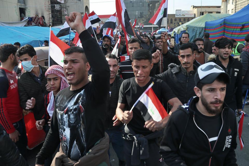 Hundreds of people march inside Tahrir Square carrying national flags and chanting religious slogans in Baghdad, Iraq, Thursday, Dec. 5, 2019. Anti-government protesters say multiple people have suffered stab wounds in Baghdad's Tahrir Square, the epicenter of their movement, after political parties and Iran-backed militia groups briefly joined them, raising fears of infiltration by authorities. (AP Photo/Hadi Mizban)