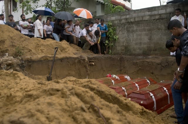 Relatives bury three victims at St Sebastian Church in Negombo