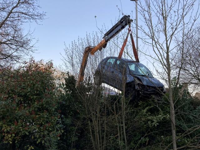 A crane lifts a car from the Robinsons&#39; garden. (SWNS)