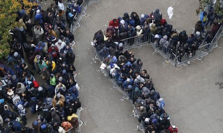Migrants queue in the compound outside the Berlin Office of Health and Social Affairs (LAGESO) as they wait to register in Berlin, Germany, October 7, 2015. German authorities are struggling to cope with the roughly 10,000 refugees arriving every day, many fleeing conflict in the Middle East. REUTERS/Fabrizio Bensch