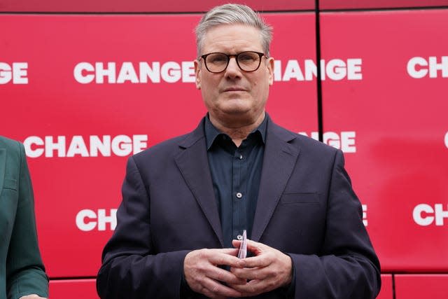 Sir Keir Starmer standing in front of a red party bus with 'change' written on it 