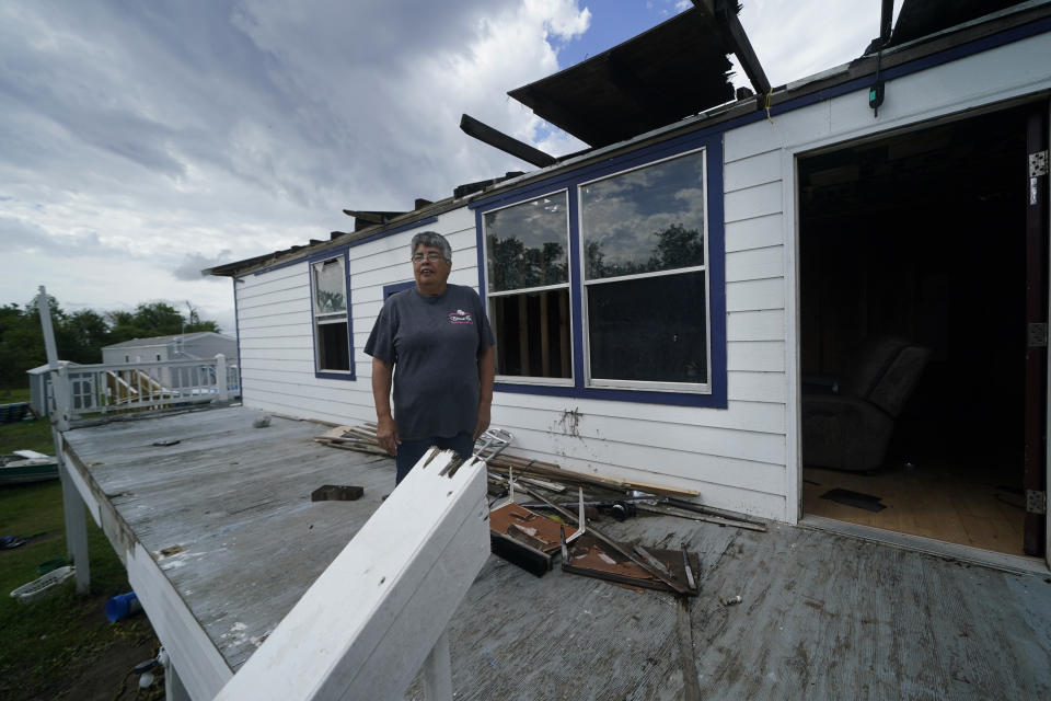 Irene Verdin stands outside her home that was heavily damaged by Hurricane Ida in August 2021, along Bayou Pointe-au-Chien, La., Tuesday, May 24, 2022. (AP Photo/Gerald Herbert)