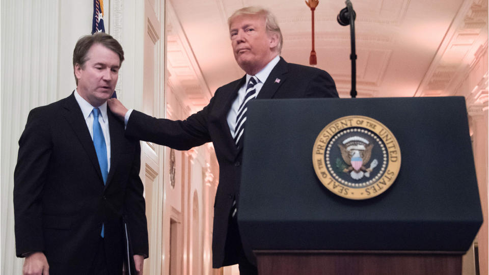 US President Donald Trump (R) pats Associate Justice of the US Supreme Court Brett Kavanaugh (L) on the back during a ceremonial swear-in at the White House in Washington, DC, on October 8, 2018. (Jim Watson/AFP via Getty Images)