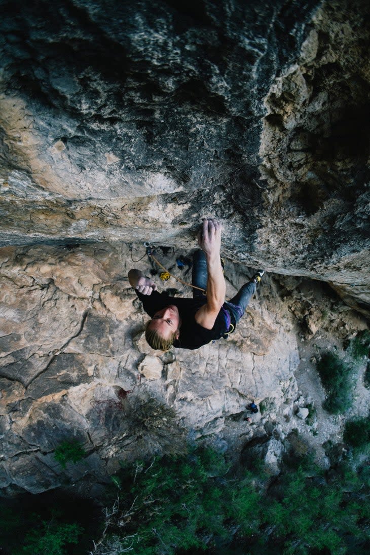Cameron Horst lurches through the redpoint crux of Martial Law, high on the upper headwall of the cave.