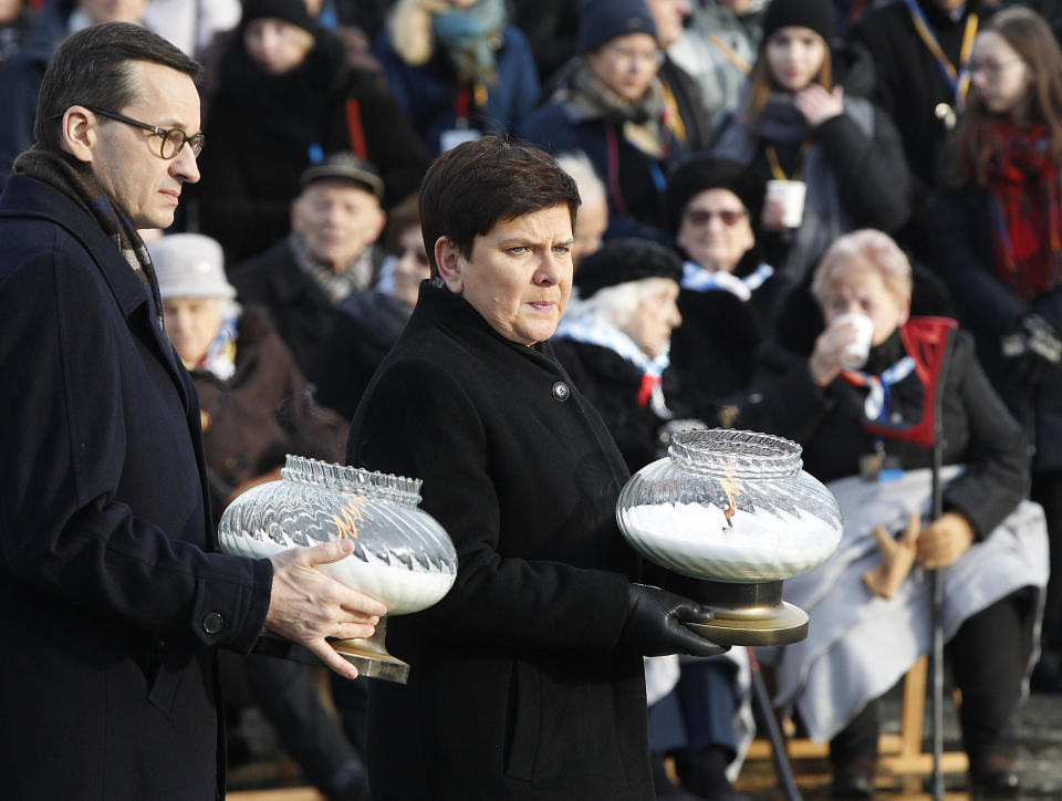 Polish Prime Minister Mateusz Morawiecki,left, and deputy Prime Minister Beata Szydlo ,right,place candles at the Monument to the Victims at the former Nazi German concentration and extermination camp Auschwitz II-Birkenau, during on International Holocaust Remembrance Day in Oswiecim, Poland, Sunday, Jan. 27, 2019.(AP Photo/Czarek Sokolowski)