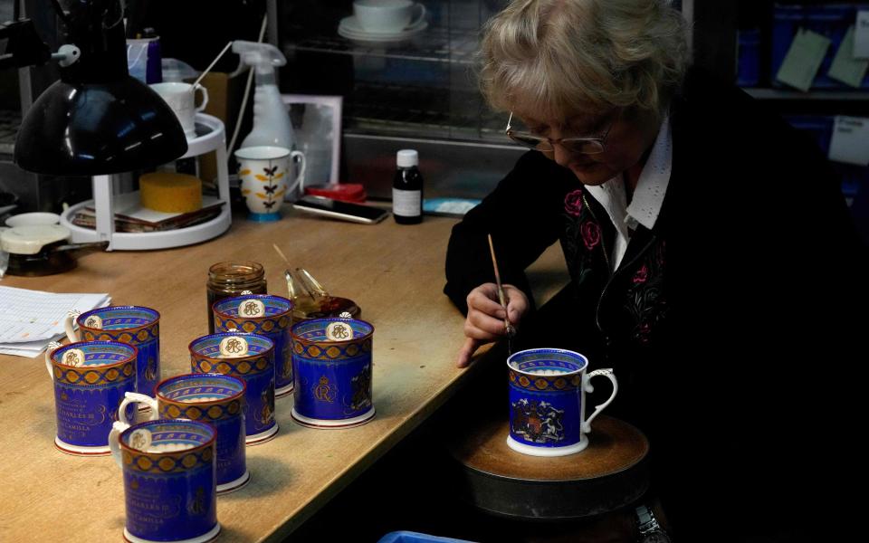 A pottery worker works on official chinaware produced for the Coronation of Britain's King Charles III at a factory in Stoke on Trent, - FRANK AUGSTEIN/POOL/AFP via Getty Images