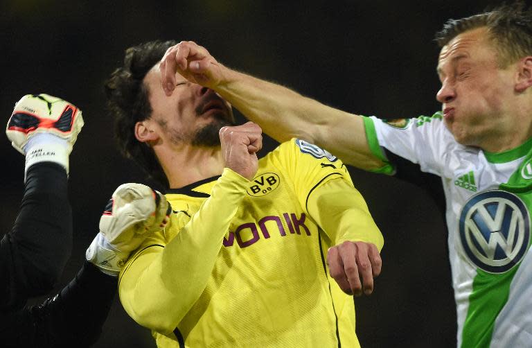 Wolfsburg's Ivica Olic (R), Dortmund's goalkeeper Roman Weidenfeller and Dortmund defender Mats Hummels (C) clash during the match in Hamburg, northern Germany, on April 15, 2014