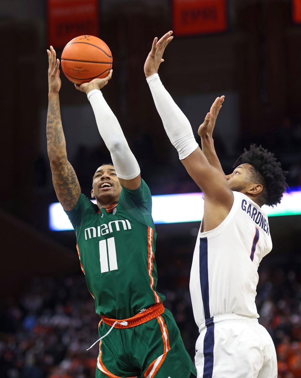 Miami guard Jordan Miller (11) shoots next to Virginia forward Jayden Gardner (1) during an NCAA college basketball game in Charlottesville, Va., Saturday, Feb. 5, 2022. (AP Photo/Andrew Shurtleff)