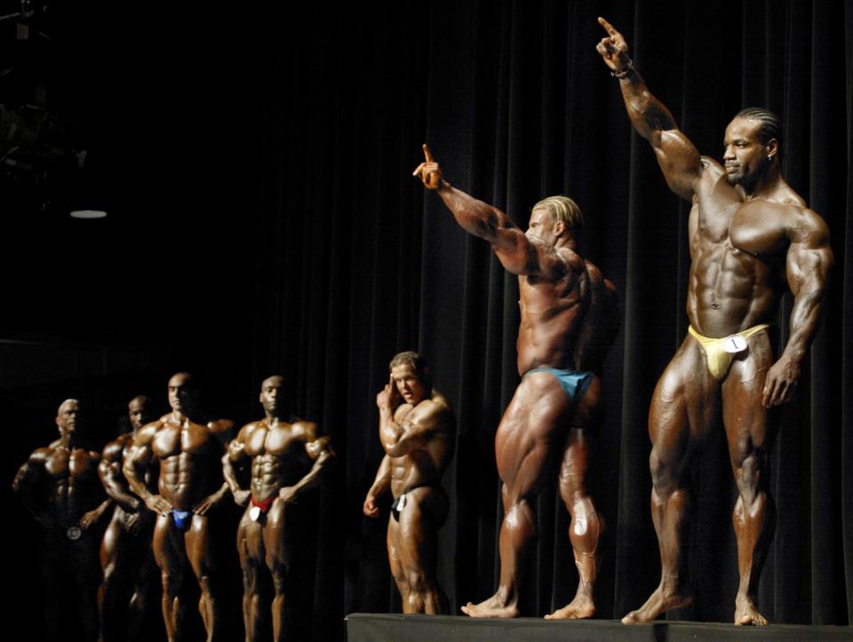 Body builders participating in the 14 annual Arnold Schwarzenegger Classic acknowledge the crowd gathered at the Veterans Memorial for the prejudging of the Classic. Body builders on the stage waving are Jay Cutler at left and Chris Cormier.
