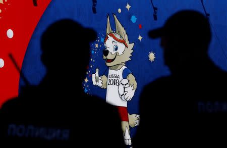 FILE PHOTO: Police officers guard in front of a board depicting Zabivaka, the official mascot for the 2018 FIFA World Cup, in St. Petersburg, Russia June 14, 2018. REUTERS/Anton Vaganov/File Photo