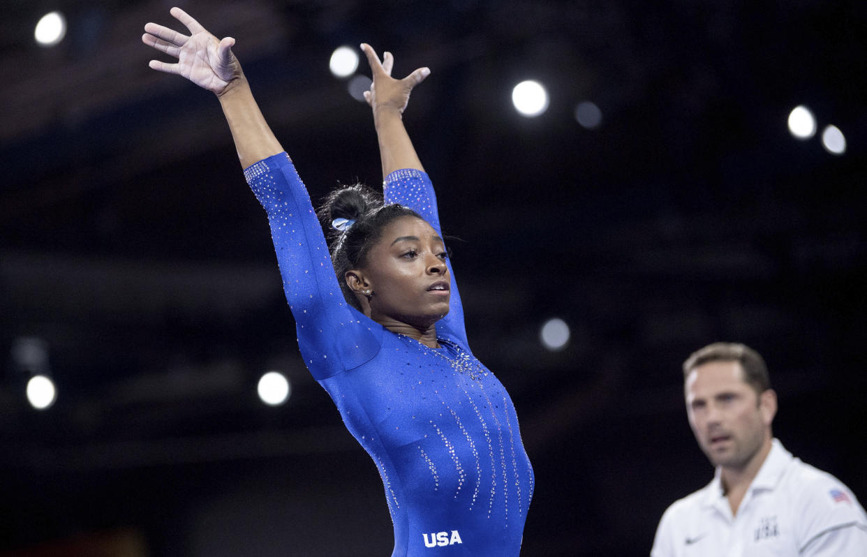 Simone Biles, of the United States, raises her arms after landing while competing in the Gymnastics World Championships in Stuttgart, Germany, Monday, Oct. 1, 2019. (Marijan Murat/dpa via AP)