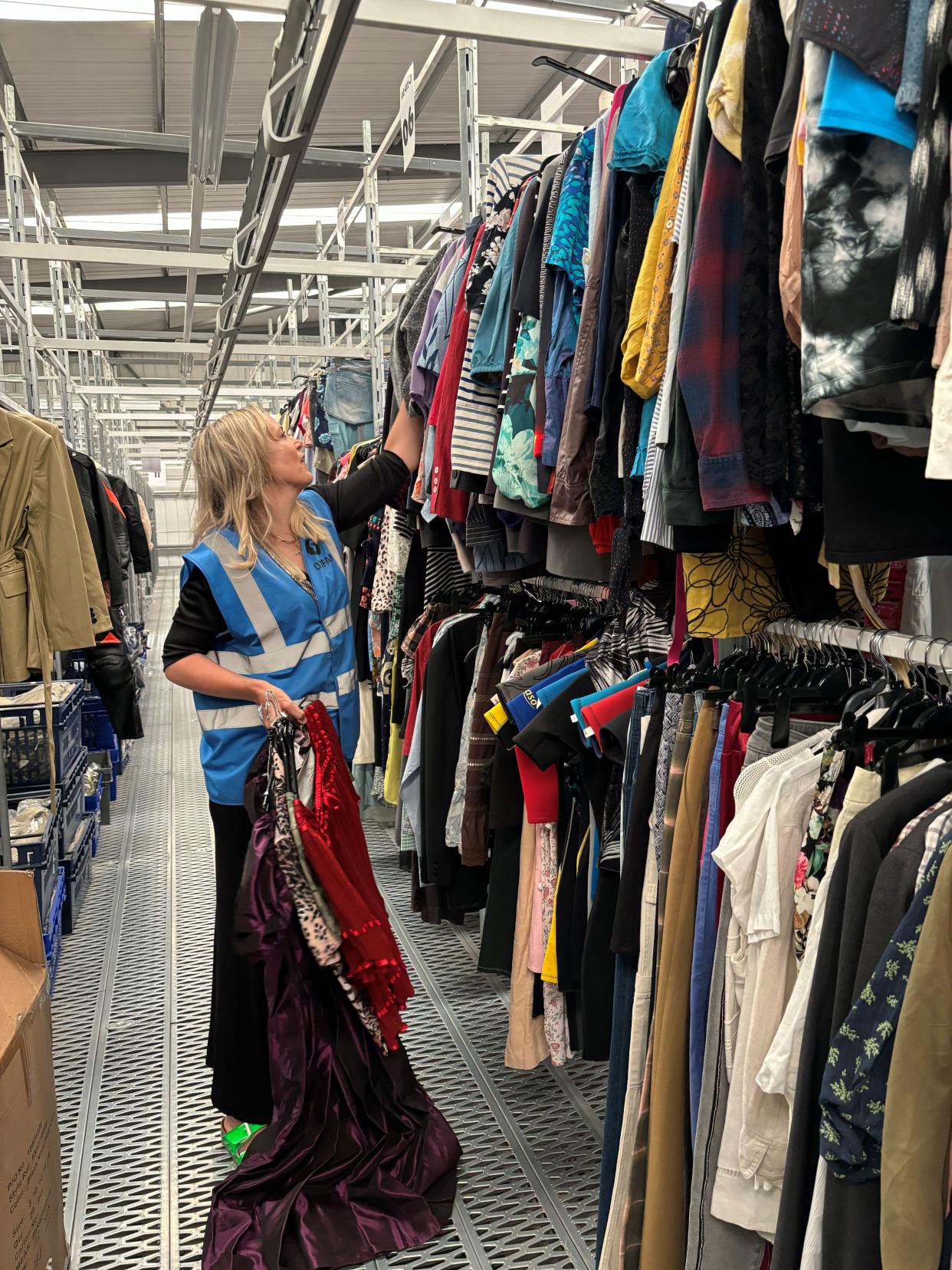 Bay Garnett searches through the rails of an Oxfam warehouse in Milton Keynes 