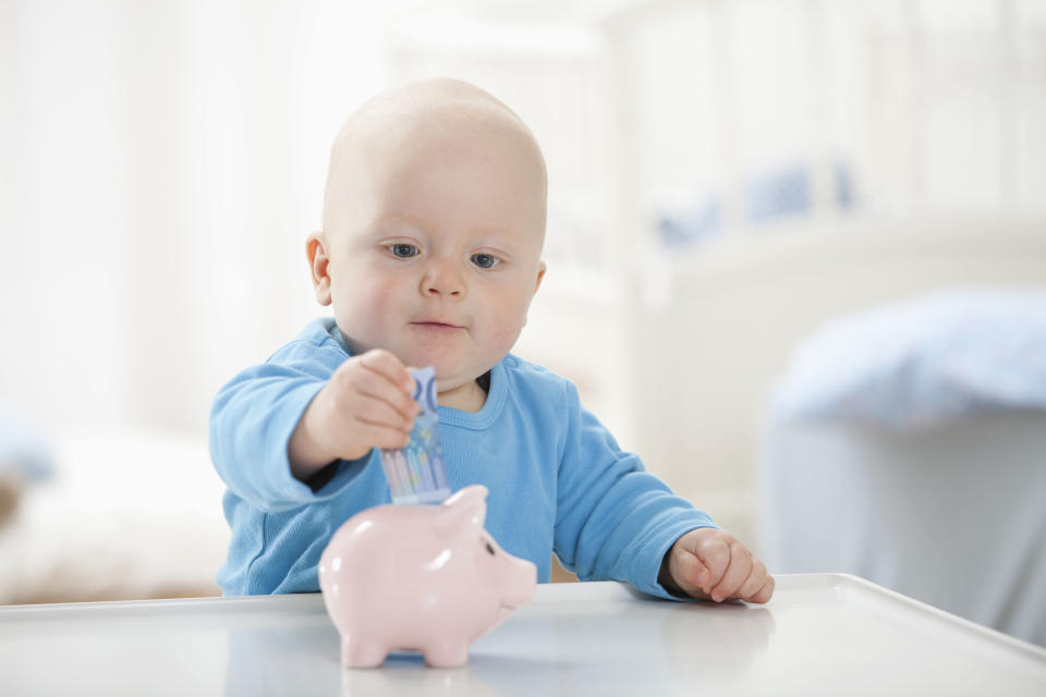 Baby putting money into a piggy bank. Source: Getty
