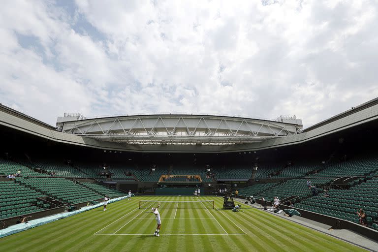 Rafael Nadal de España, arriba, practica contra Matteo Berrettini de Italia en la cancha central antes del Campeonato de Wimbledon 2022 en el All England Lawn Tennis and Croquet Club, en Londres, el jueves 23 de junio de 2022. (Steven Paston/PA vía AP)