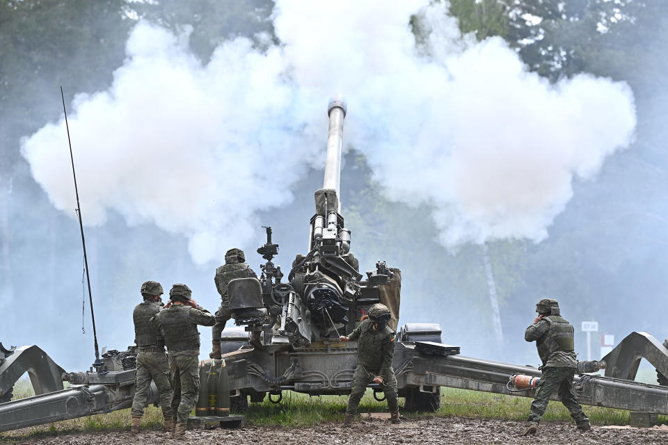 Soldiers fire a howitzer during military exercises.